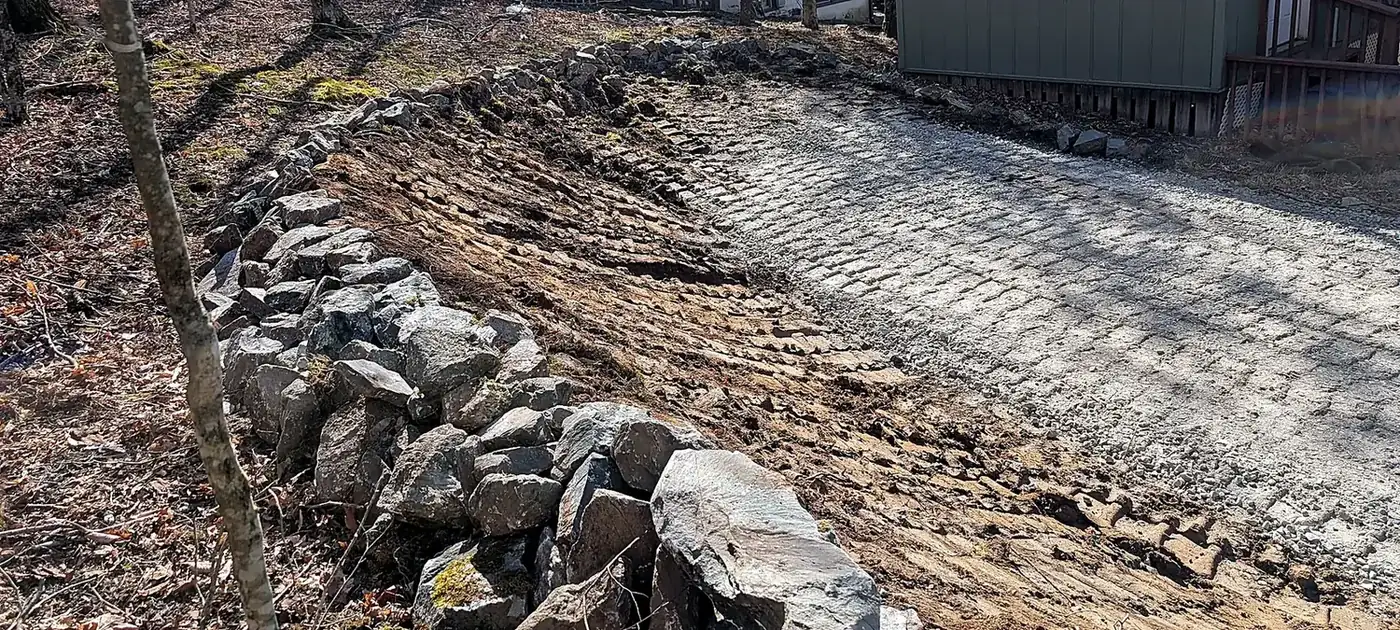 Rock-lined drainage and erosion-control work beside a building services by 3 George's Grading