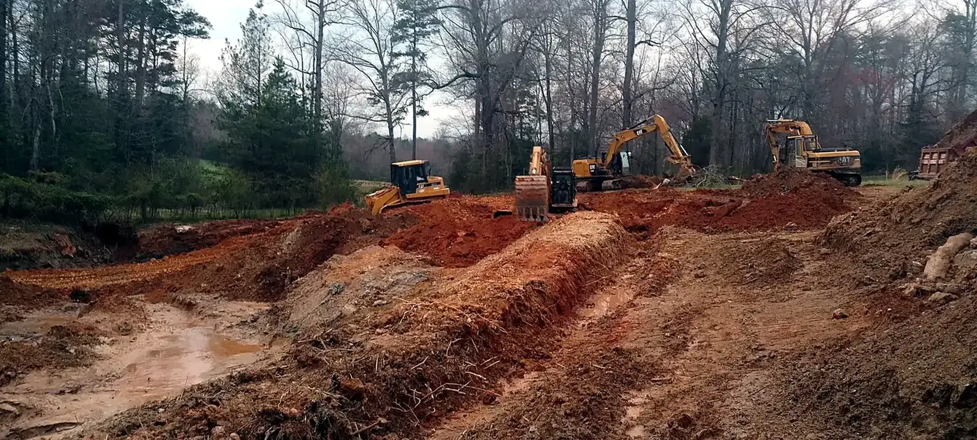 Excavation equipment working across a prepared red-clay jobsite services by 3 George's Grading