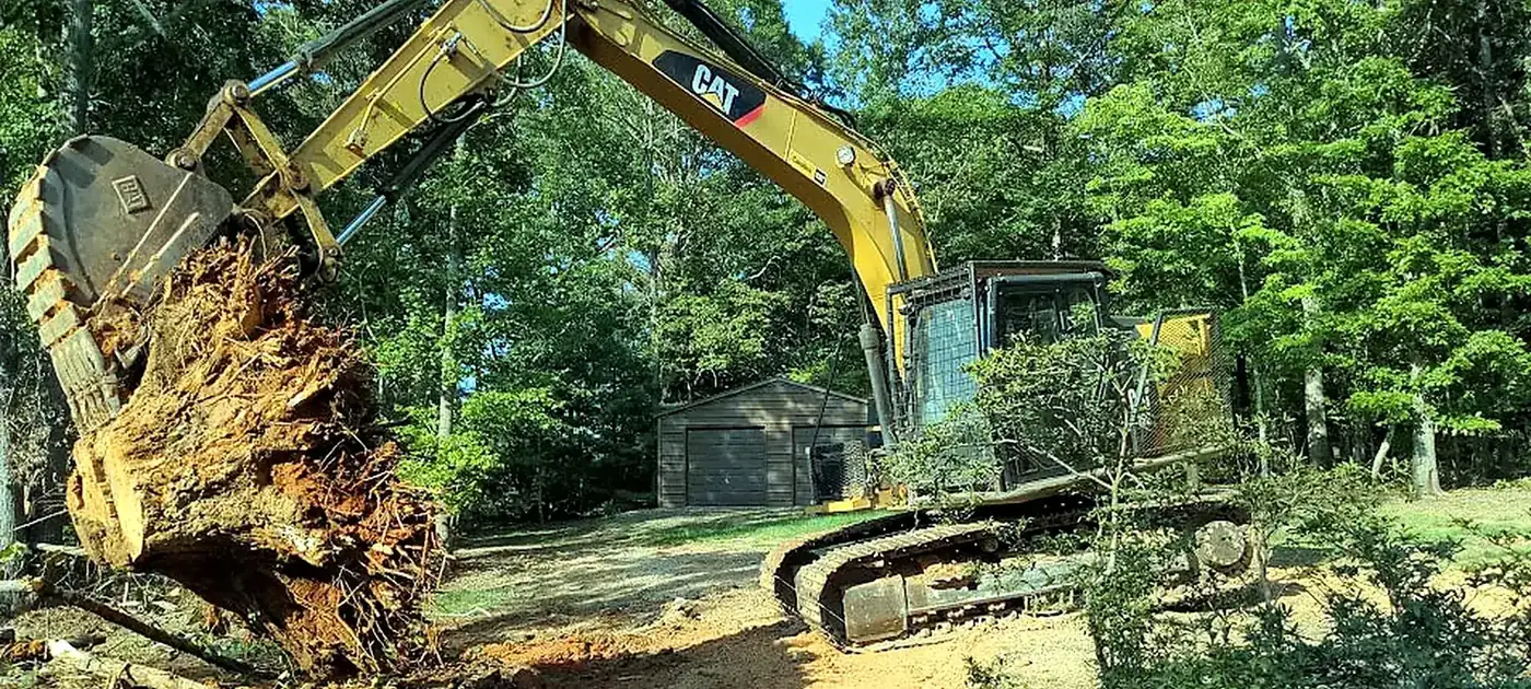 Excavator lifting a large stump and root ball services by 3 George's Grading